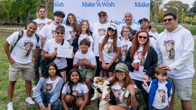 Team Anthony, a big group, poses in front of the step-and-repeat