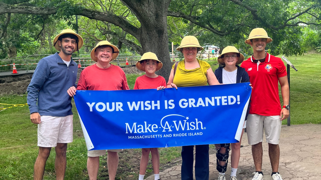 Ian at his wish reveal with his family and Make-A-Wish representatives