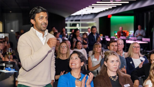 Emerging Philanthropist award winner Rishi Dixit standing on the left with the audience behind them